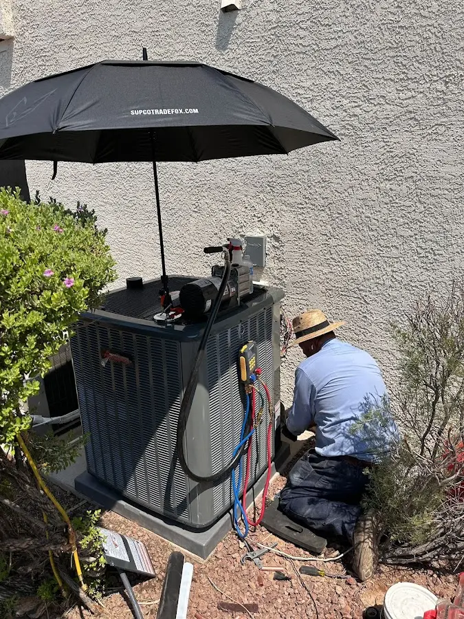 HVAC technician performing outdoor AC maintenance in Talent