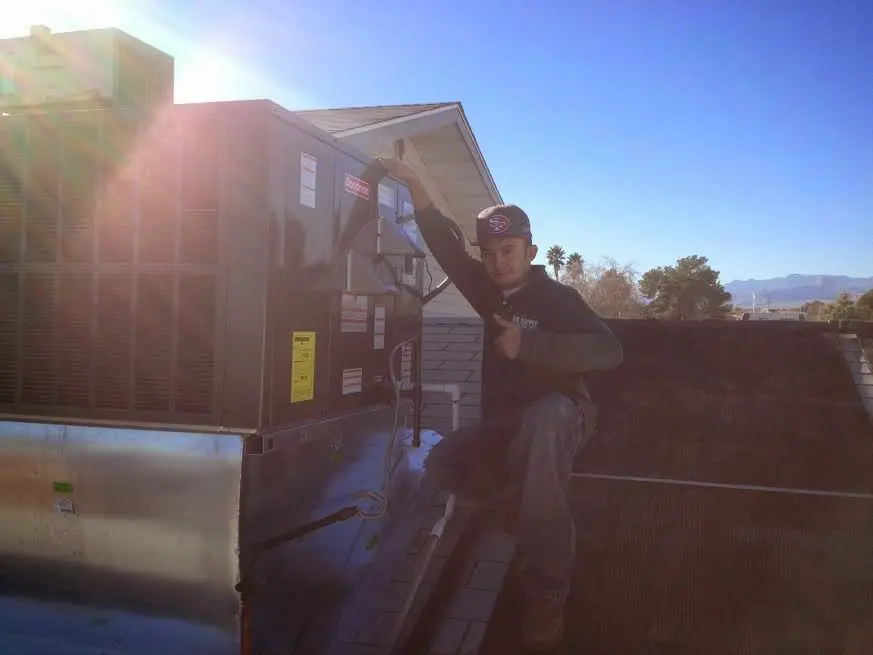 HVAC technician performing Air Duct Cleaning on a rooftop unit in Talent